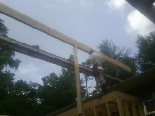 Carpenter setting a ridge beam over a new addition frame — Ice Dam Removal by Roofing Brothers in Columbia